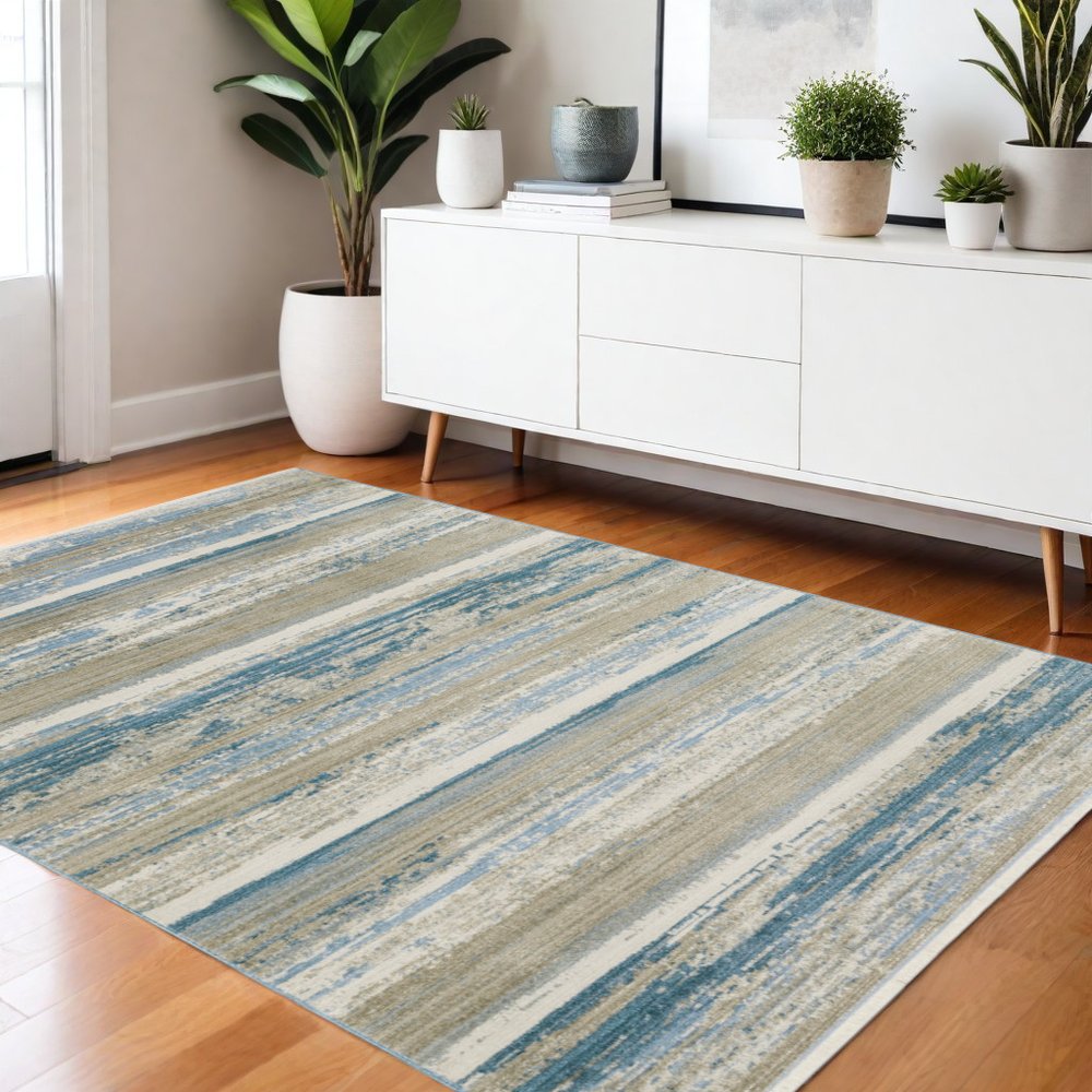 4' X 6' Ivory Beige Grey Blue And Tan Abstract Power Loom Stain Resistant Area Rug With Fringe