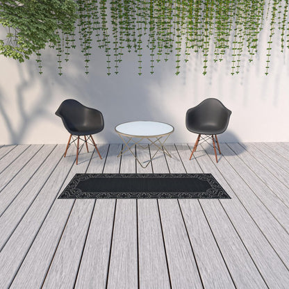 2' X 8' Black and Ivory Stain Resistant Indoor Outdoor Area Rug