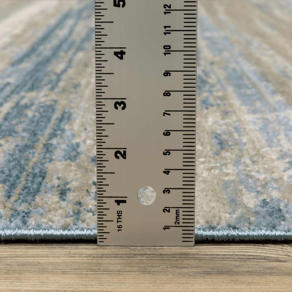 4' X 6' Ivory Beige Grey Blue And Tan Abstract Power Loom Stain Resistant Area Rug With Fringe
