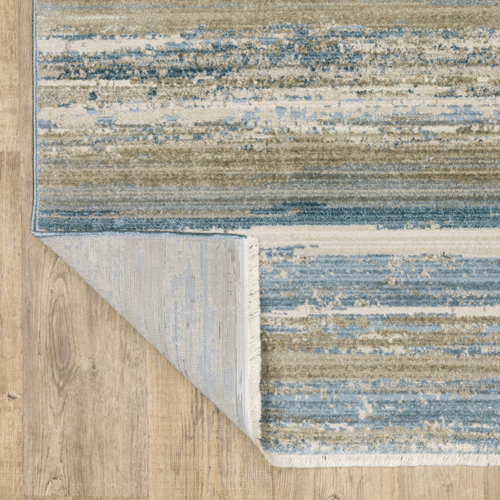 6' X 9' Ivory Beige Grey Blue And Tan Abstract Power Loom Stain Resistant Area Rug With Fringe