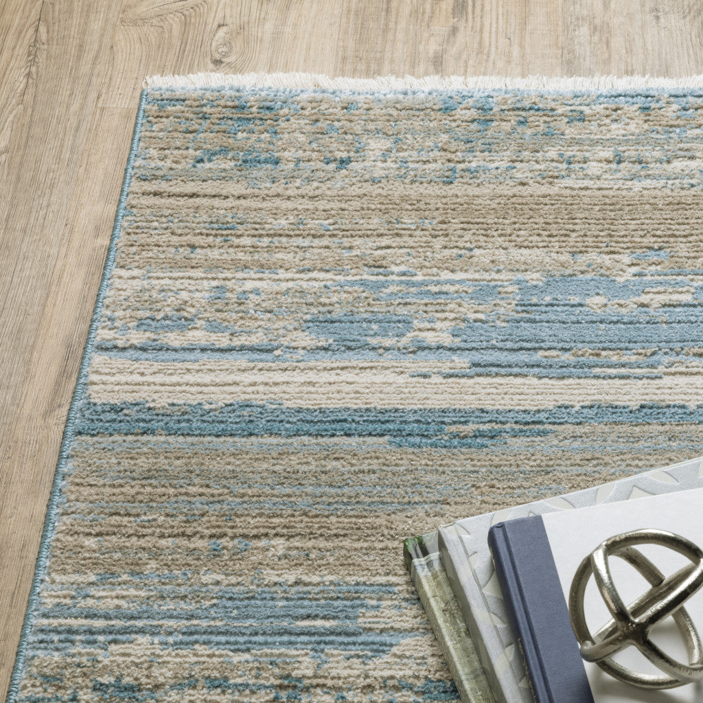 8' X 11' Ivory Beige Grey Blue And Tan Abstract Power Loom Stain Resistant Area Rug With Fringe