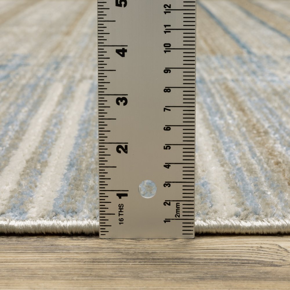 5' X 8' Blue Dark Blue Teal Grey Ivory Beige And Tan Geometric Power Loom Stain Resistant Area Rug With Fringe