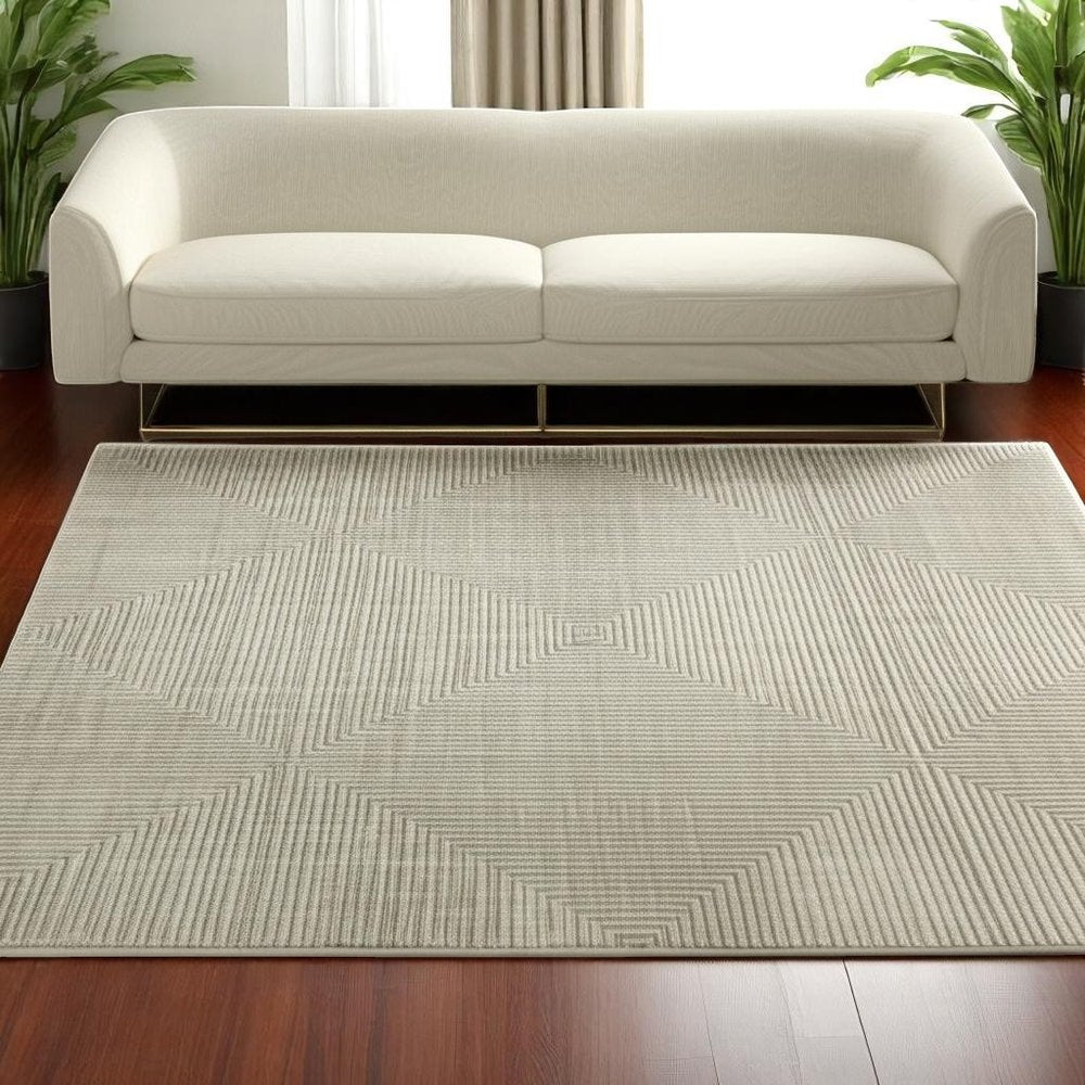5' X 8' Ivory Beige Taupe And Tan Geometric Power Loom Stain Resistant Area Rug With Fringe