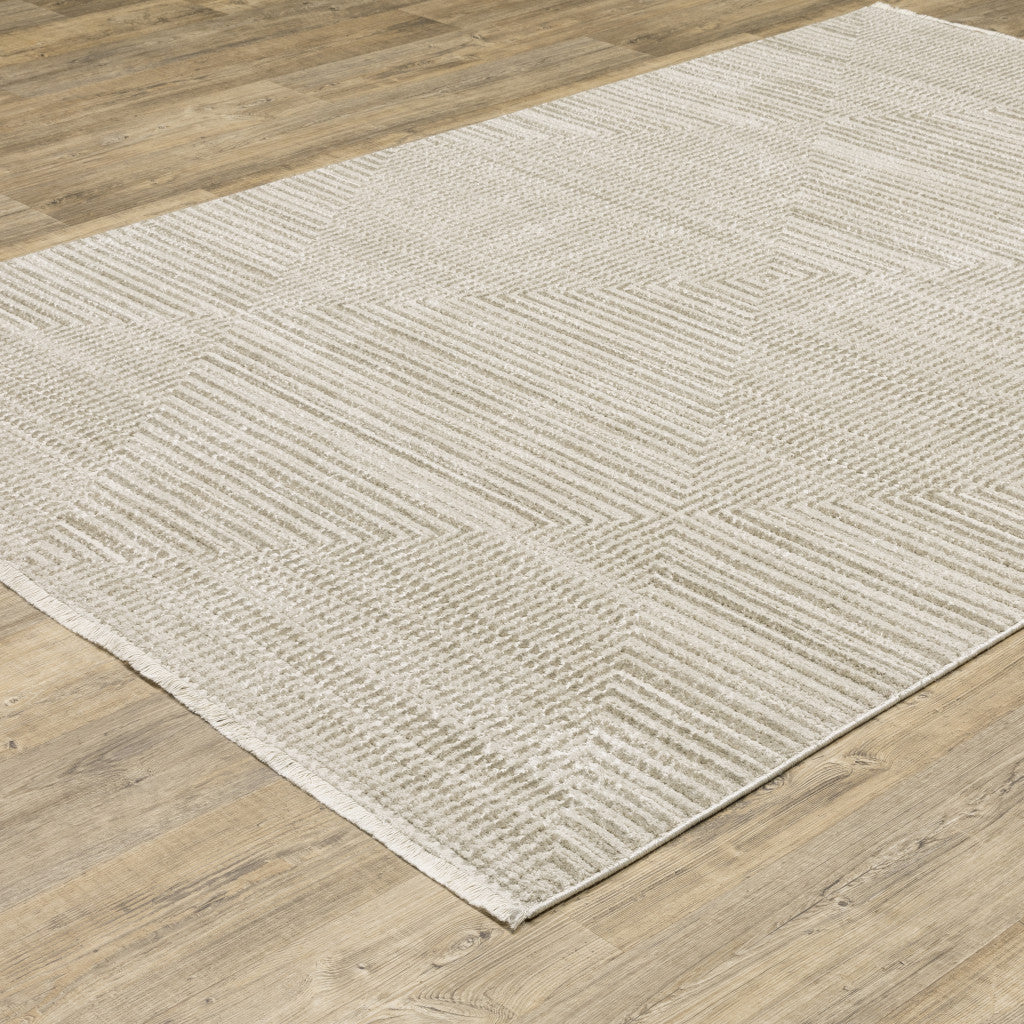 5' X 8' Ivory Beige Taupe And Tan Geometric Power Loom Stain Resistant Area Rug With Fringe